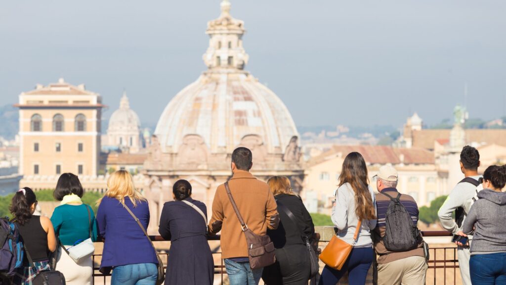 Turisti di spalle che praticano turismo culturale, ammirando i monumenti a Roma