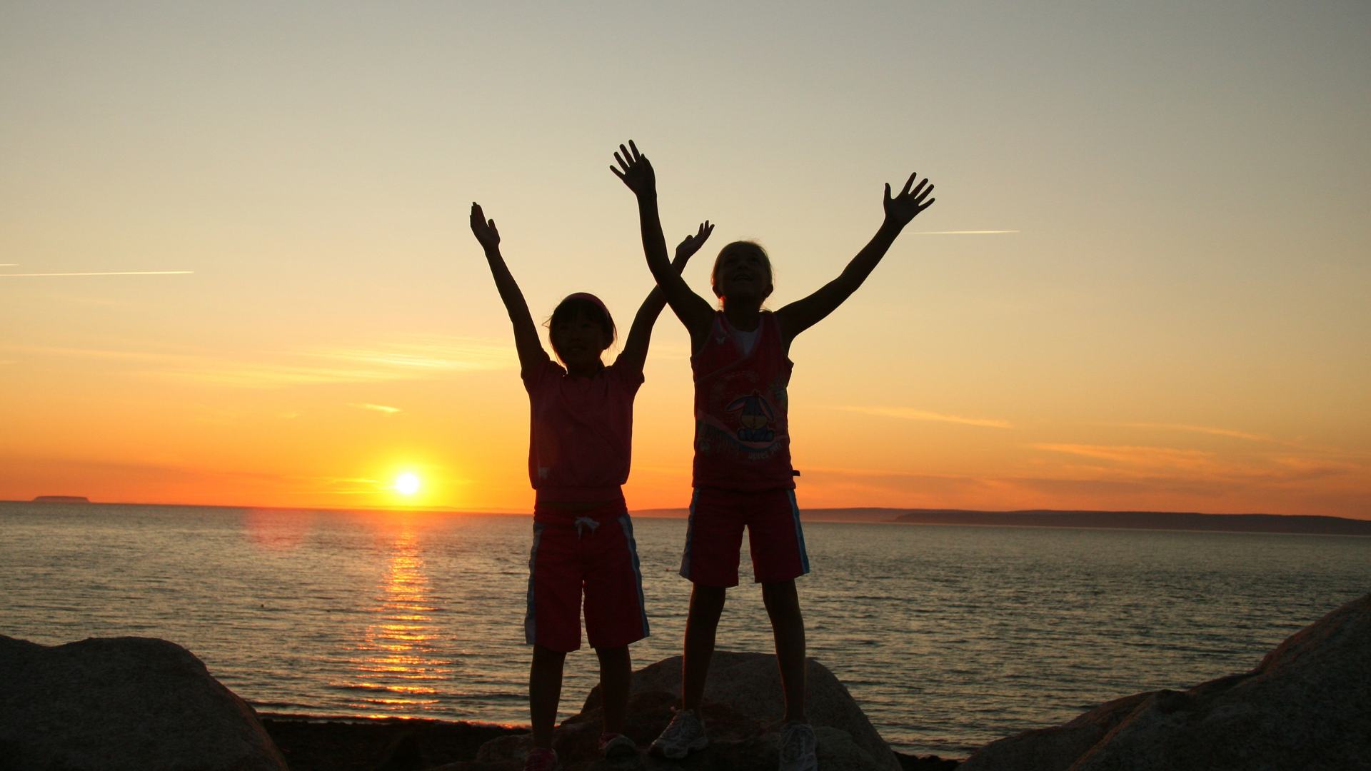 Bambini fronte mare durante il tramonto