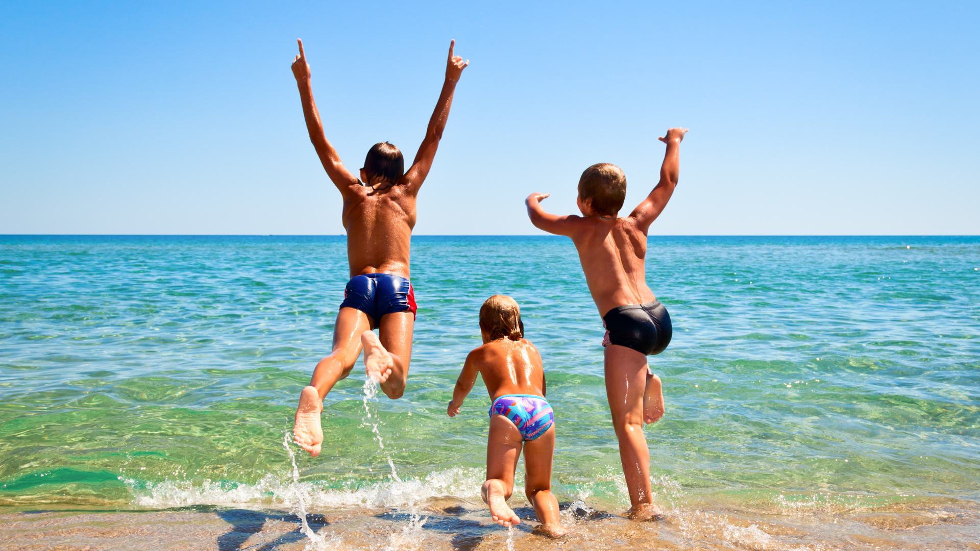 Bambini che giocano in acqua al mare