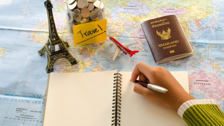 Mappa con quaderno, passaporto e statuetta Tour Eiffel per scelta del viaggio